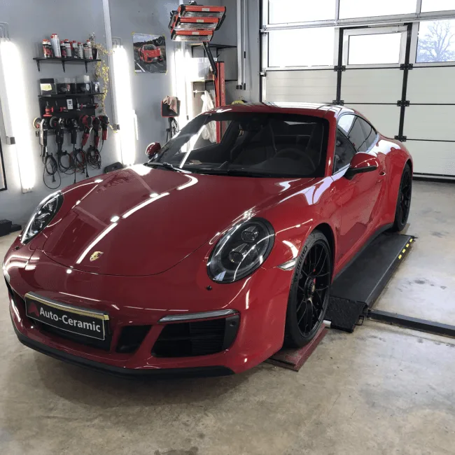 Roter Porsche 911 GTS mit glänzendem Lack in der Werkstatt