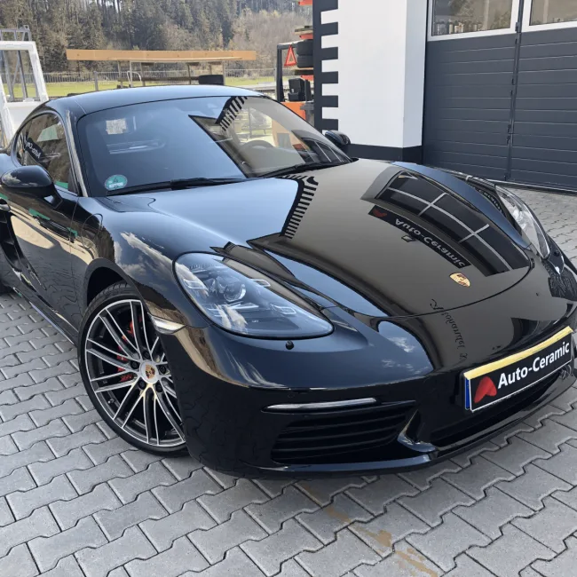 Schwarzer Porsche 718 mit glänzendem Lack vor der Werkstatt
